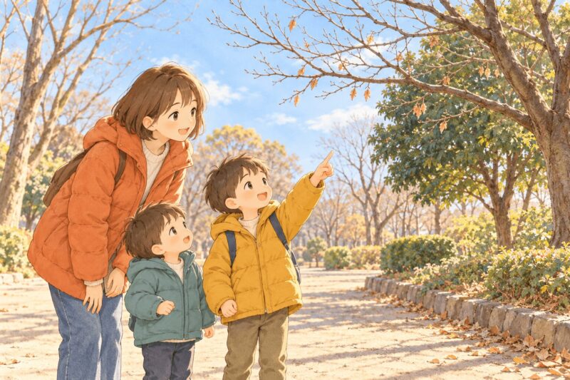 雪のない冬の公園で、木の枝を指さしながら自然を観察する親子